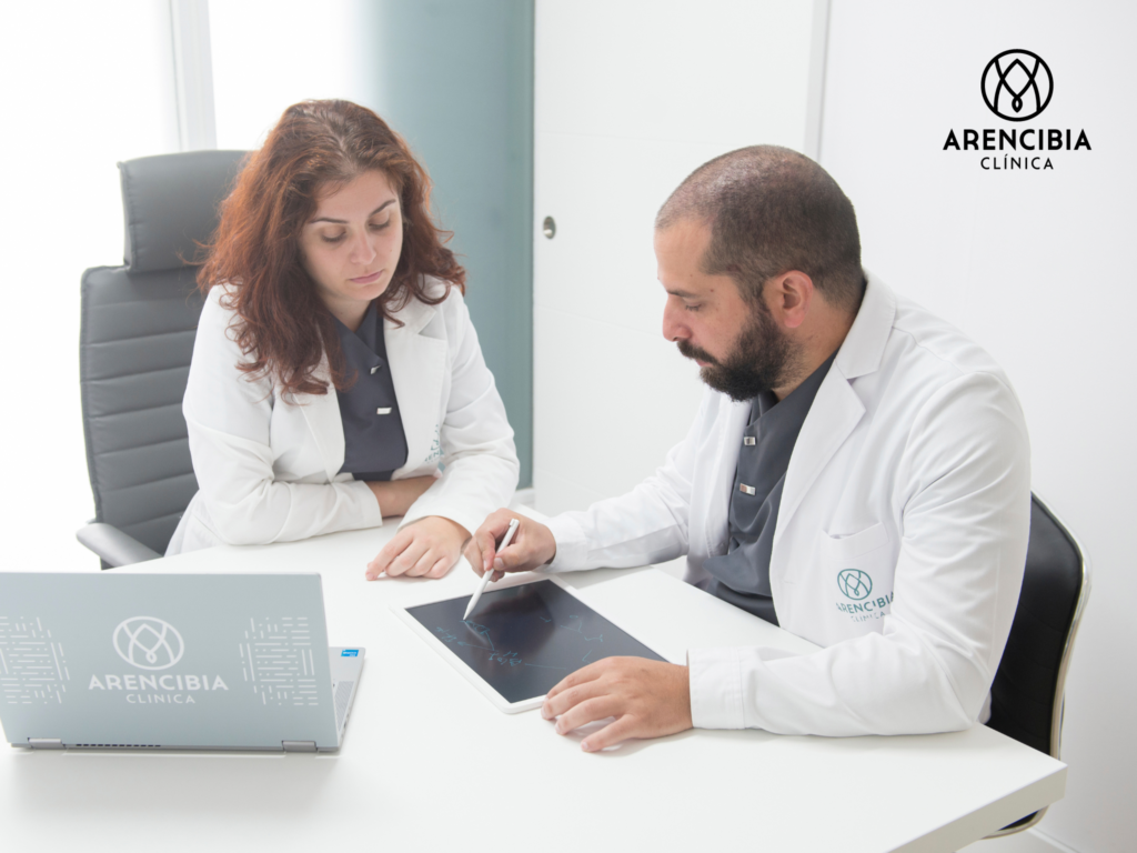 Los doctores Guerrero y Arencibia estudian las características de un caso de trasplante capilar. 